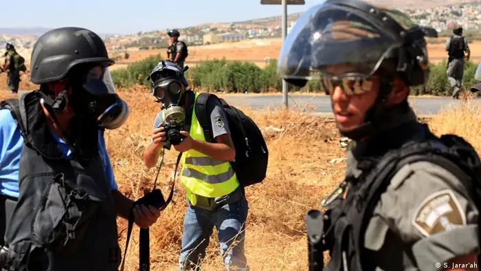 Activestills' photographer, Ahmad Al-Bazz, is seen in the picture (middle) during the coverage of clashes between Palestinian youth and Israeli occupation army, Beit Furik village, West Bank, August 08, 2014. Photo by: Shadi Jarar'ah.