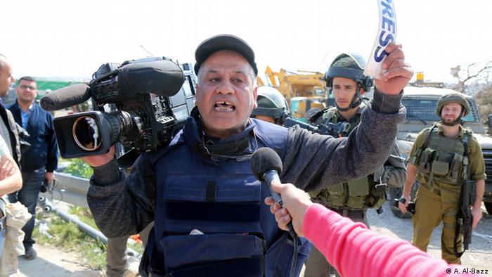 Palestinian journalist show his protest after being attacked by Israeli army during his coverage of a peaceful protest against occupation, Abu Dis, West Bank, March 17, 2015. BY: Ahmad Al-Bazz.