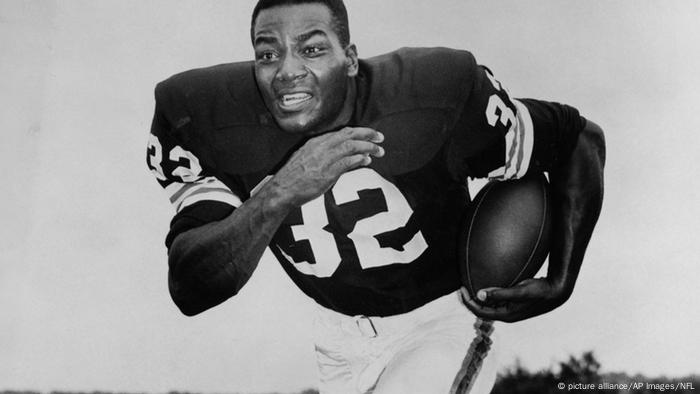 Jim Brown in football gear running with the ball