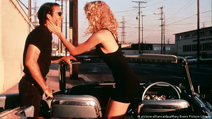 Filmstill aus Wild at Heart mit Nicolas Cage und Laura Dern, sich begrüßend in einem Auto in LA (picture-alliance/dpa/Mary Evans Picture Library)