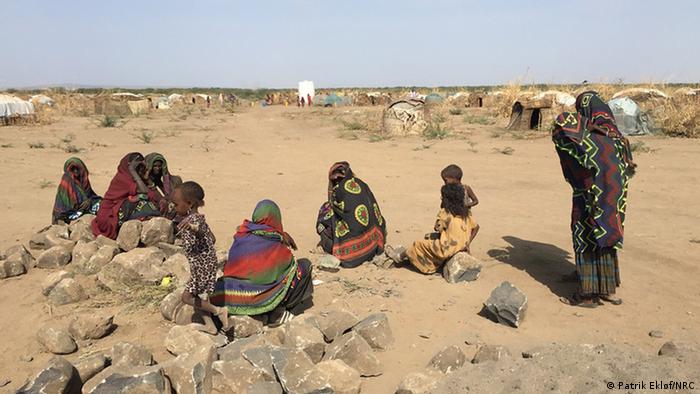 Residents of Asubuli village sit outside in Ethiopia's Somali Region.