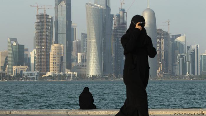 Zwei Frauen besuchen die Uferpromenade am Persischen Golf gegenüber den Wolkenkratzern von Dohas Finanzviertel