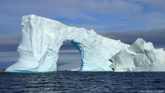 A big cliff of ice jutting out into the sea 