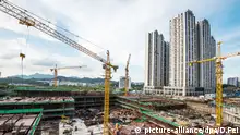 picture-alliance/dpa/D.Fei Symbolbild --FILE--A view of the construction site of a residential property project in Shenzhen city, south China's Guangdong province, 8 June 2015. China will reduce or stop issuing land for new residential housing projects in areas where there is a supply glut, the latest in a series of measures aimed at clearing a property overhang weighing on the economy. China's land ministry will not release vacant land to commercial property developers in cities and other areas where there are large levels of unsold inventory, state television reported on Sunday (21 February 2016), citing a ministry meeting. China has announced a string of measures designed to boost the housing market, a crucial driver of the economy. Real estate investment affects more than 40 other sectors in China, from cement to furniture.