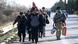 Migrants and refugees walk along a road to cross the Greek-Macedonian border near the village of Idomeni Migrants and refugees walk along a road to cross the Greek-Macedonian border near the village of Idomeni