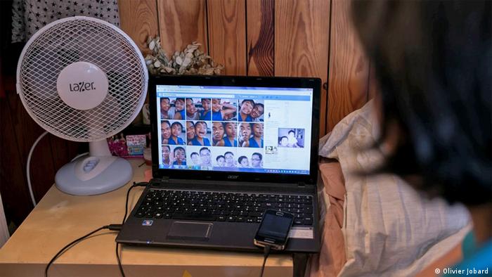 Gemma's laptop propped on a nightstand in her small Paris room shows images of her son