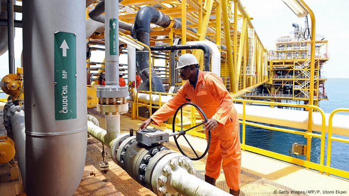 A worker inspects some pipes on a drilling platform in Nigeria