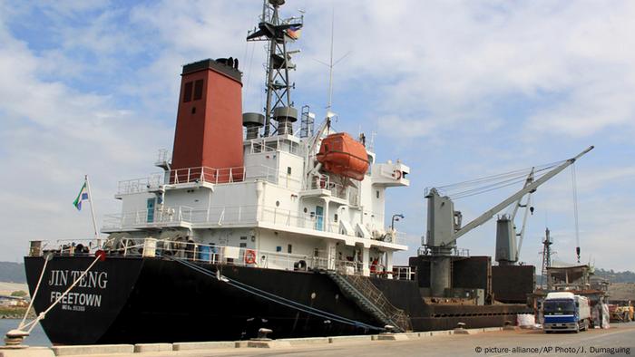 Crewmen of the North Korean cargo vessel Jin Teng stand on the middle of the deck as it unloads its cargo while docked at Subic Bay, in Zambales province, northwest of Manila, Philippines