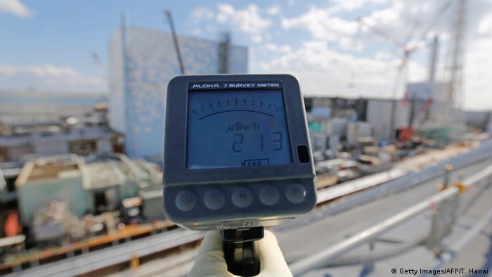 A Tepco employee measures a radiation level of 213 mikrosieverts in front of Fukushima reactors 2 and 3 (Photo: Getty Images/AFP/T. Hanai)