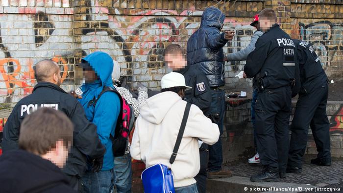 Police officers searching African men during a police operation in Berlin in 2014