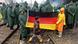Children in rain gear hold up a German flag over train tracks in Idomeni Children in rain gear hold up a German flag over train tracks in Idomeni