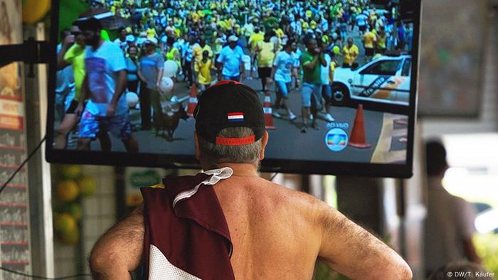 Mann guckt Demo im TV