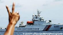 29.08.2014 (c) picture-alliance/ANN/GrigMontegrande A Philippine Marine soldier flashes the peace sign to a Chinese Coast Guard ship after it tried to block a resupply vessel from restocking the BRP Sierra Madre on Ayungin Shoal in March