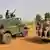 The Nigerian army patroling in Chibok, Borno State includes two vehicles: one is mounted with two manned machine guns, while the other is a pick-up truck withmore than have a dozen soldiers riding in the back