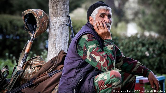 Человек, сидящий рядом с оружием