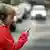 Menino com fone de ouvido e celular atravessando a rua