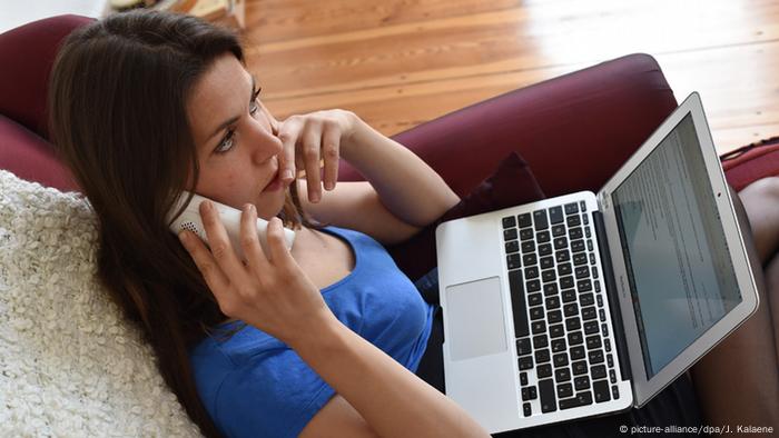 Woman with phone and laptop, Copyright: picture-alliance/dpa/J.  Kalaene