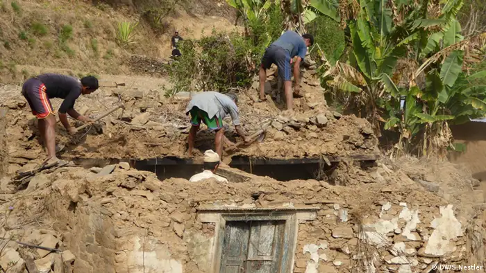 Bewohner von Kadambas arbeiten in den Trümmern ihres Hauses