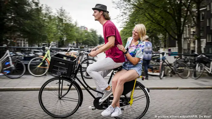 Niederlande Amsterdam 2 Menschen auf Fahrrad 