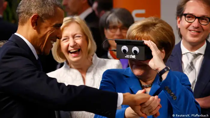 Während des Eröffnungsrundgangs auf der Hannover-Messe witzeln Bundeskanzlerin Angela Merkel und US-Präsident Barack Obama. Merkel hält einen Kasten vor ihren Augen, auf dem Kulleraugen aufgeklebt sind. Obama lacht. (Foto: Reuters/K. Pfaffenbach)