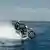 Stuntman on motorbike driving on open sea