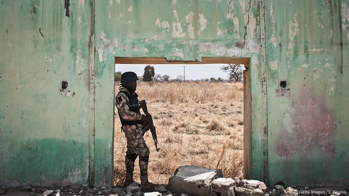 Nigeria Afrika Soldat steht in einem Türrahmen eines zerstörten Gebäudes