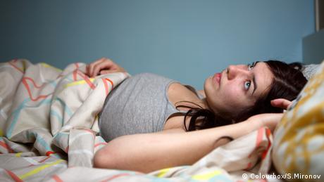 A woman lying in bed, unable to sleep