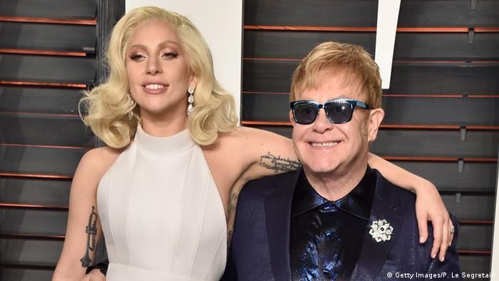 Lady Gaga with her arm around Elton John.