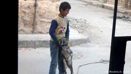 Syrien Aleppo Junge spielt mit Hund