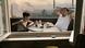 A boy and a man sit on a balcony in front of an industrial landscape A boy and a man sit on a balcony in front of an industrial landscape