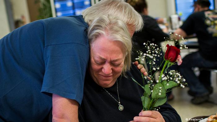 Ein Mann umarmt eine Frau, die eine Rose hält (Foto: Reuters)