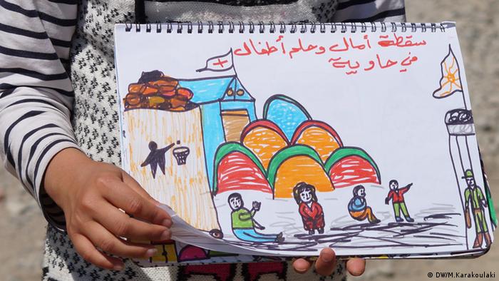 A refugee girl holding a painting (photo: Marianna Karakoulaki) 