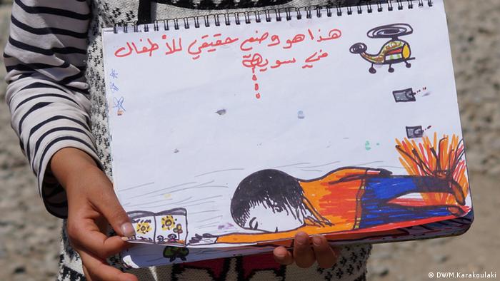 A refugee girl holding a painting (photo: Marianna Karakoulaki)