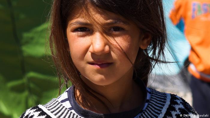 A refugee girl holding a painting (photo: Marianna Karakoulaki)