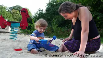 Deutschland Schwangere Mutter mit kleinem Jungen auf dem Spielplatz