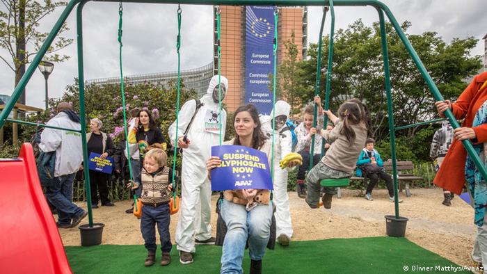 Members of Avaaz dressed in full chemical protection gear demonstrate in front of the European Commission in Brussels (Photo: Olivier Matthys/Avaaz)
