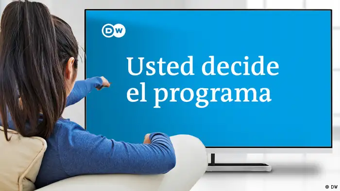 Una joven está sentada en un sillón frente a un televisor. En la pantalla se puede ver la frase Usted decide el programa y el logotipo de DW.
