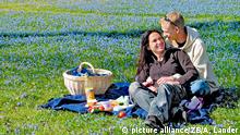 Umgeben von vielen blauen Cillas machen es sich Aileen Hartwig (22) und Otto Mueller (26) am 01.04.2005 im Magdeburger Nordpark bei einem Picknick gemütlich. Der April startete mit viel Sonnenschein und milden Temperaturen. Foto: Andreas Lander +++(c) dpa - Report+++ | Verwendung weltweit picture alliance/ZB/A. Lander
