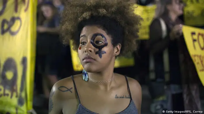 A woman wearing a female gender symbol attends a protest against the gang rape of a 16-year-old girl in Rio de Janeiro
