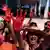 Manifestantes mostram mãos vermelhas de tinta em manifestação em Brasília em maio de 2016
