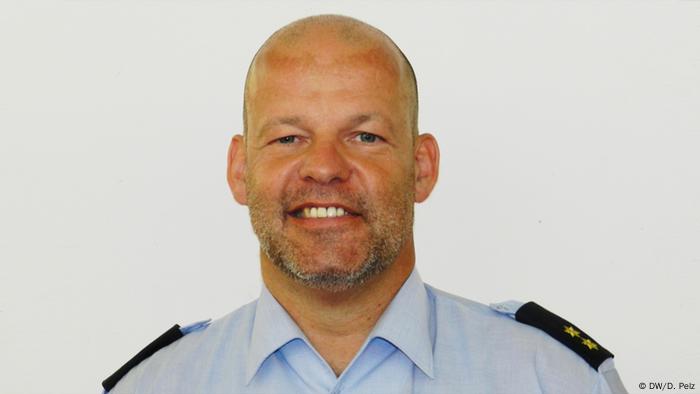 Portraitfoto von Meinolf Schlotmann in einer blauen Polizeiuniform.
