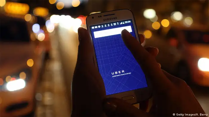 Deutschland App Uber - Smartphone neben Taxis