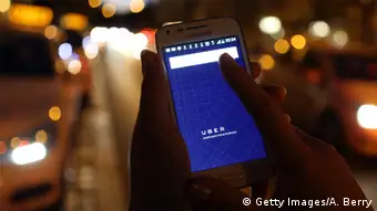 Deutschland App Uber - Smartphone neben Taxis