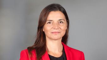 Alexandra von Nahmen wears a red blazer and looks into the camera