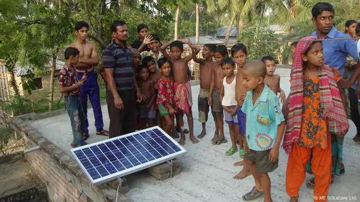 Bangladesch Photovoltaik: Kinder bestaunen ein Solarmodul. 