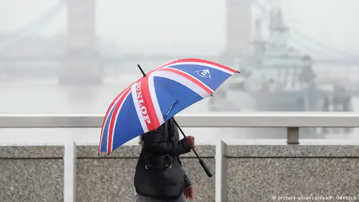 Großbritannien London Frau geht mit Union Jack Regenschirm über die Tower Bridge