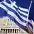 People wave Greek and EU flags outside the Greek parliament in Athens