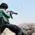 A Syrian rebel fires an assault rifle at "Islamic State" targets