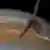 Ilustração mostra sonda Juno fazendo voo rasante em Júpiter