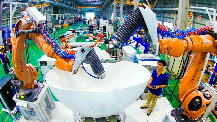 Automatización y robots junto con trabajadores de una fábrica china.